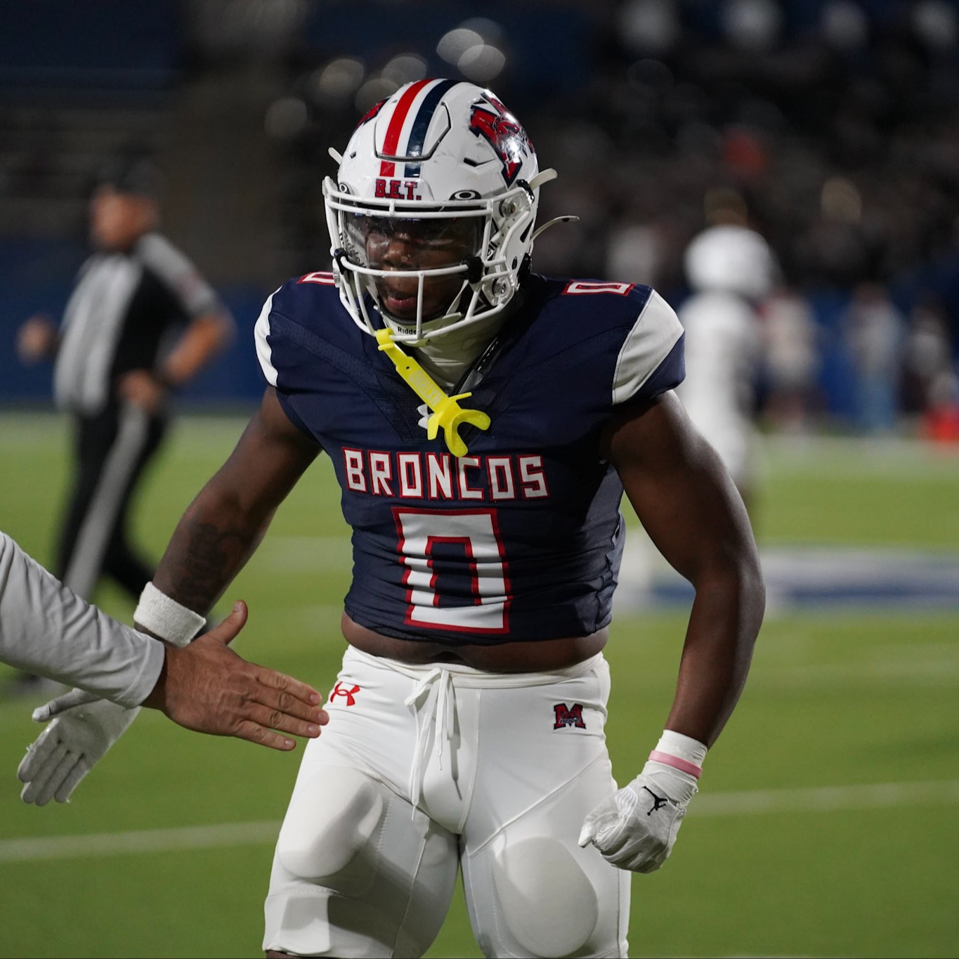 Football player celebrating with a coach on the sideline