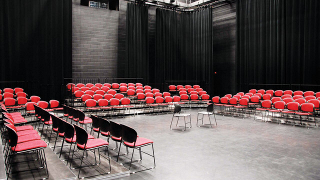 The interior of the Blackbox Theater at the Robson Performing Arts Center with red chairs set up for a performance at the center of the room