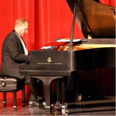 A man playing a Steinway Grand Piano