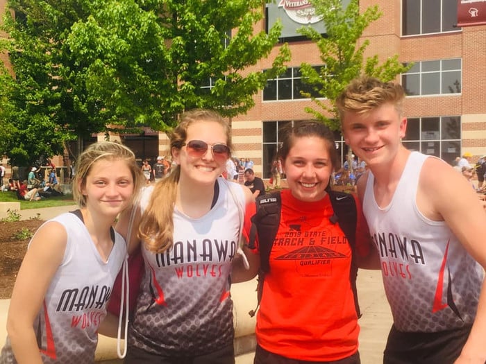 four students smiling at the camera