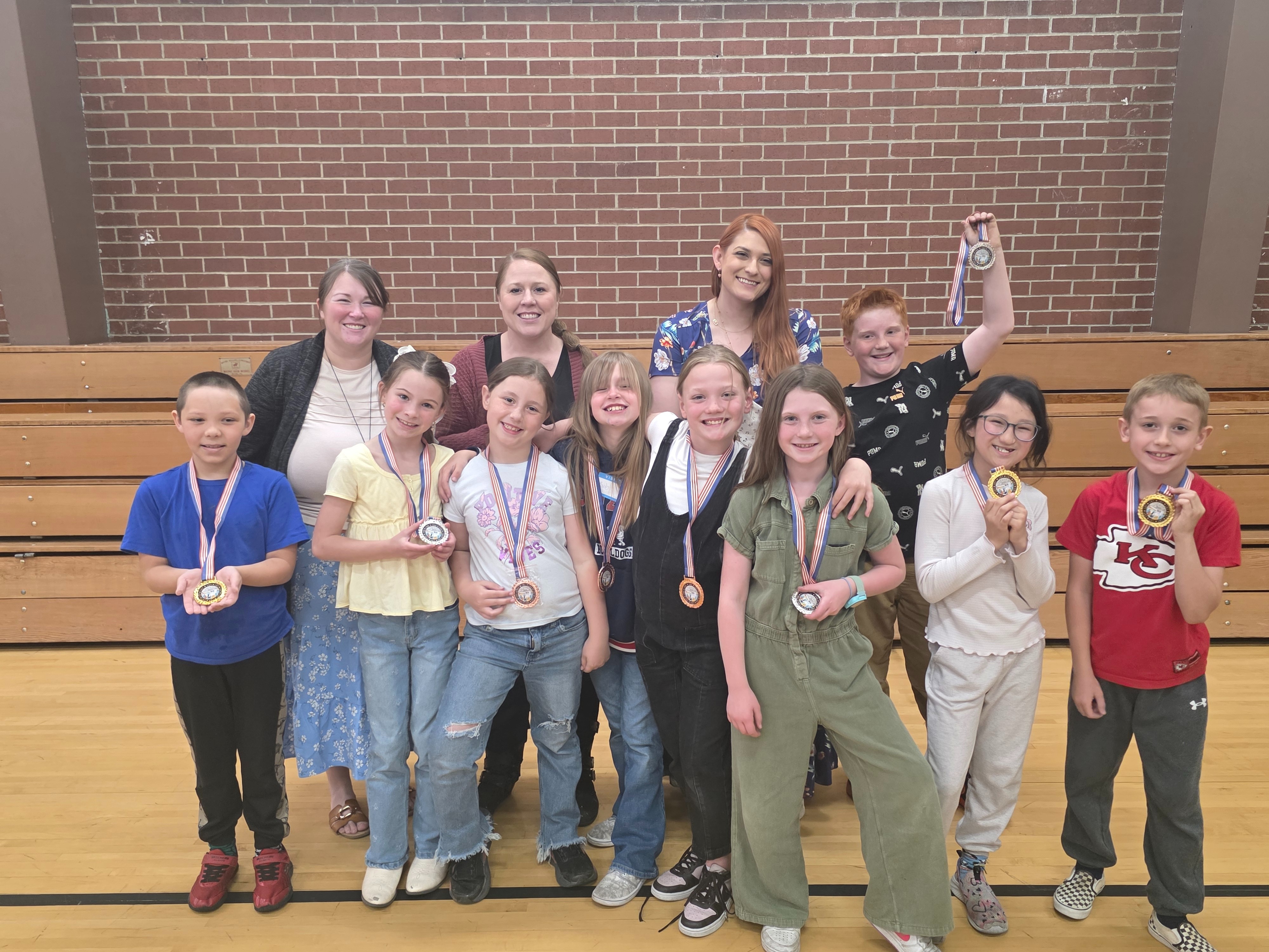 students and teachers posing with awards