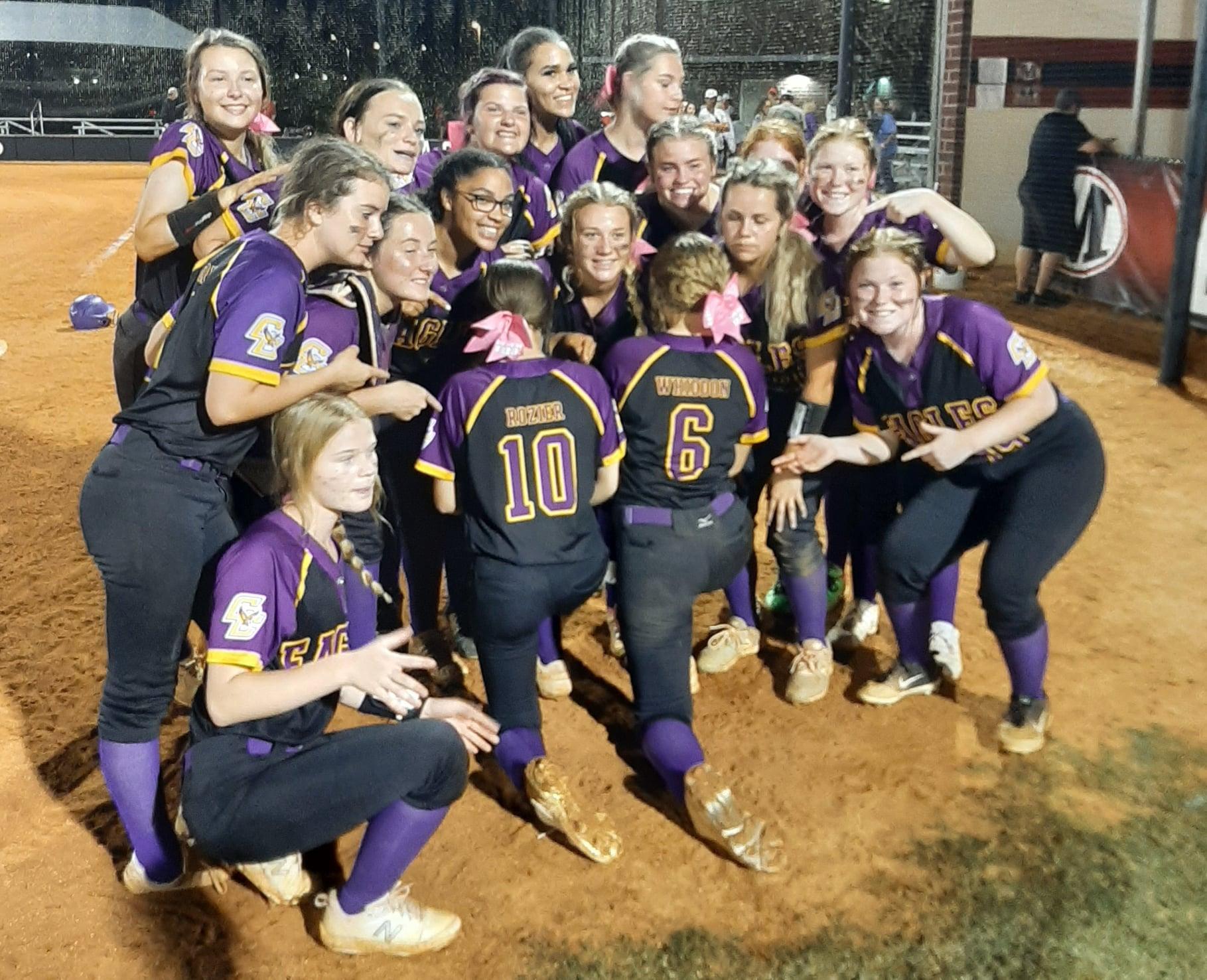 softball team girls posing for a picture on the field