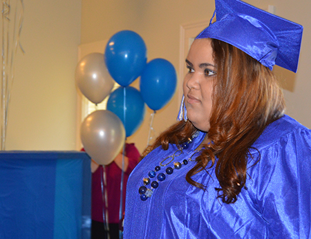 A woman in a blue graduation gown and cap