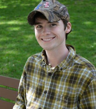 A man sitting on a bench wearing a hat