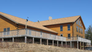 A large wooden house sitting on top of a hill