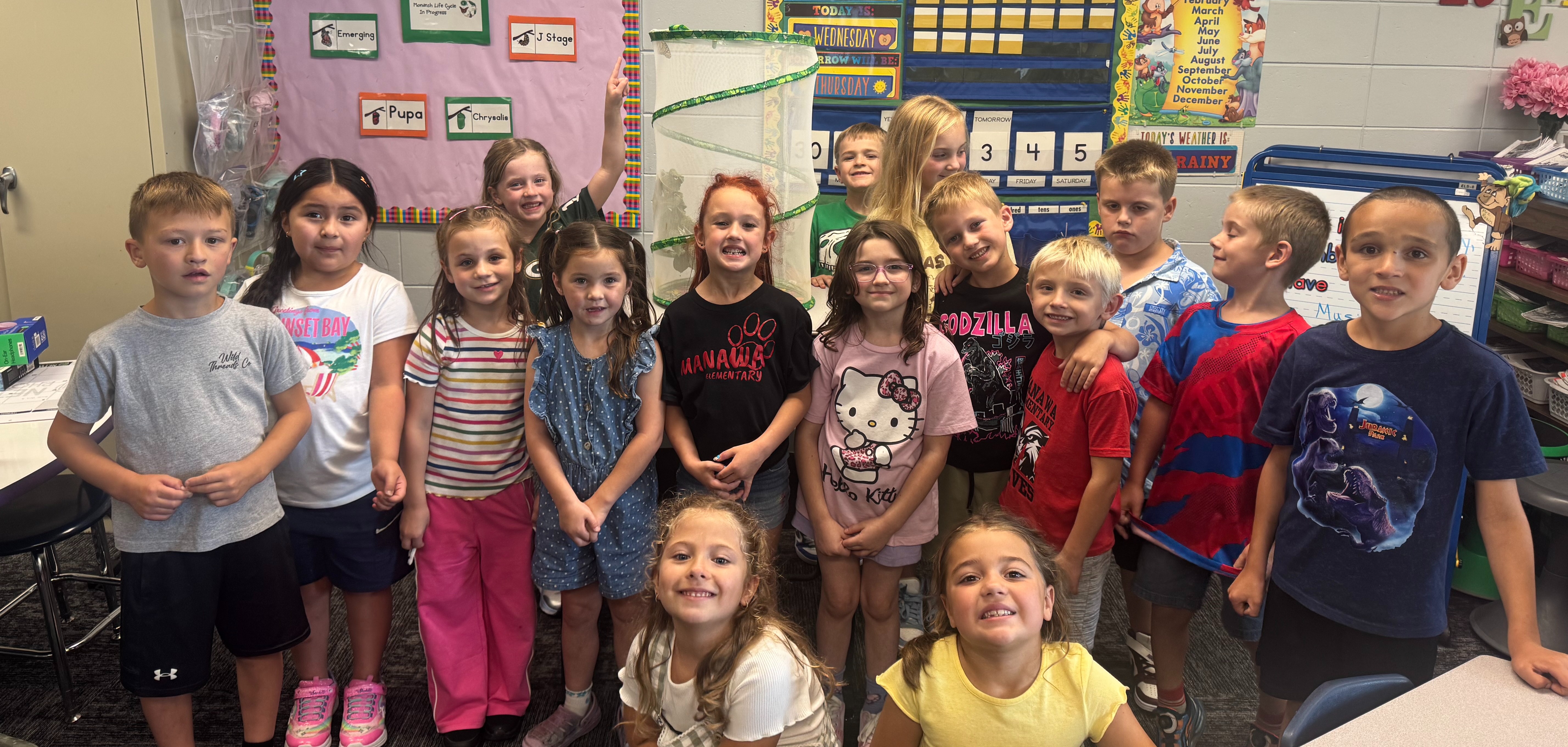 1st graders in classroom with butterfly net behind them