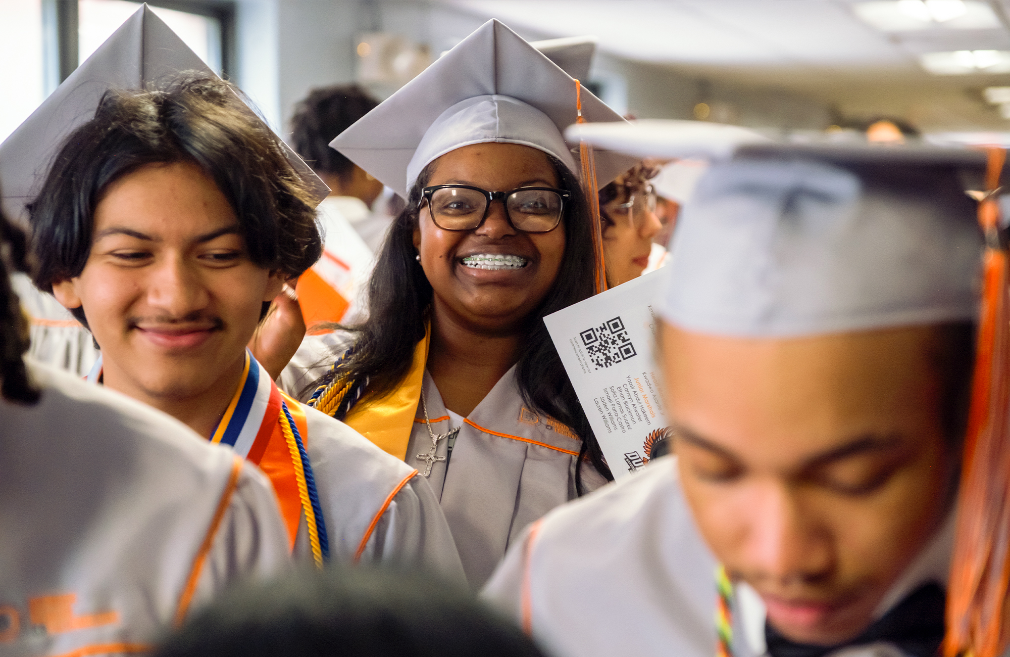 Durham School of Technology student in crowd of graduates, smiling