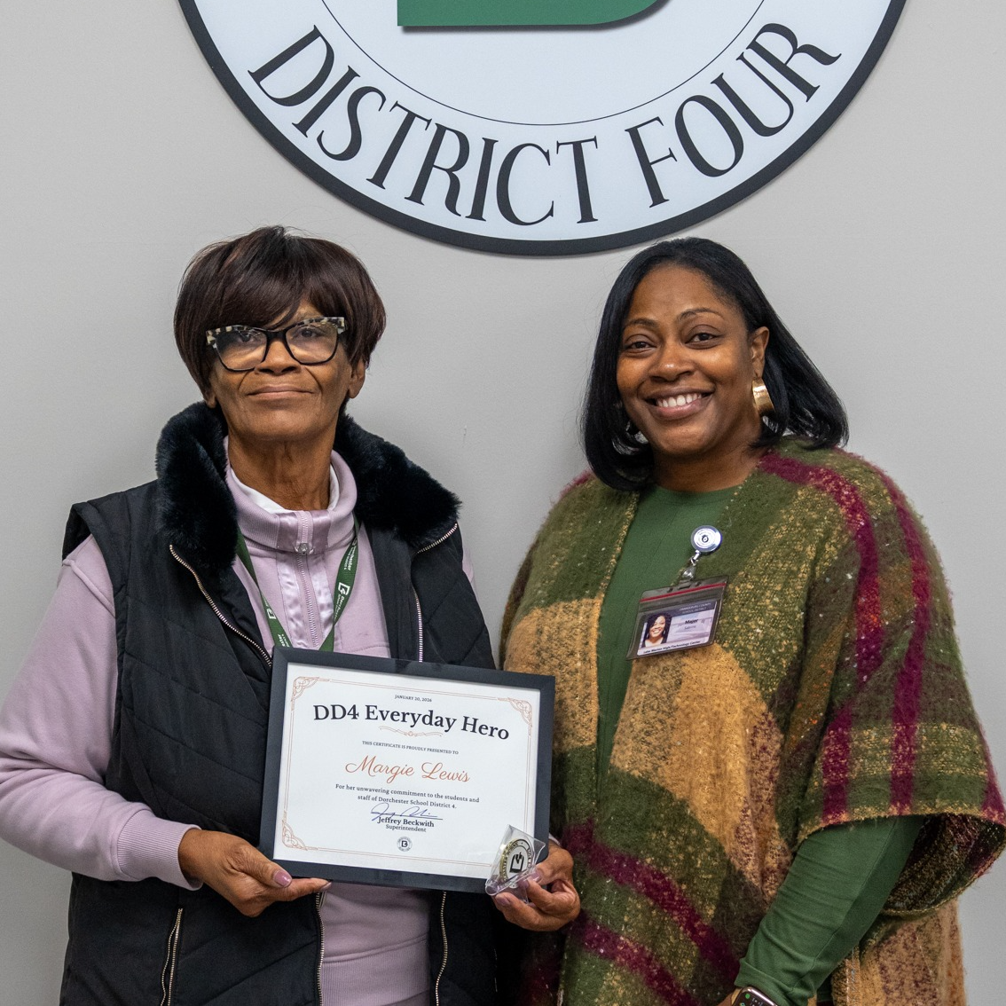 Margie Lewis and her family posing under a DD4 logo after receiving the everyday hero award