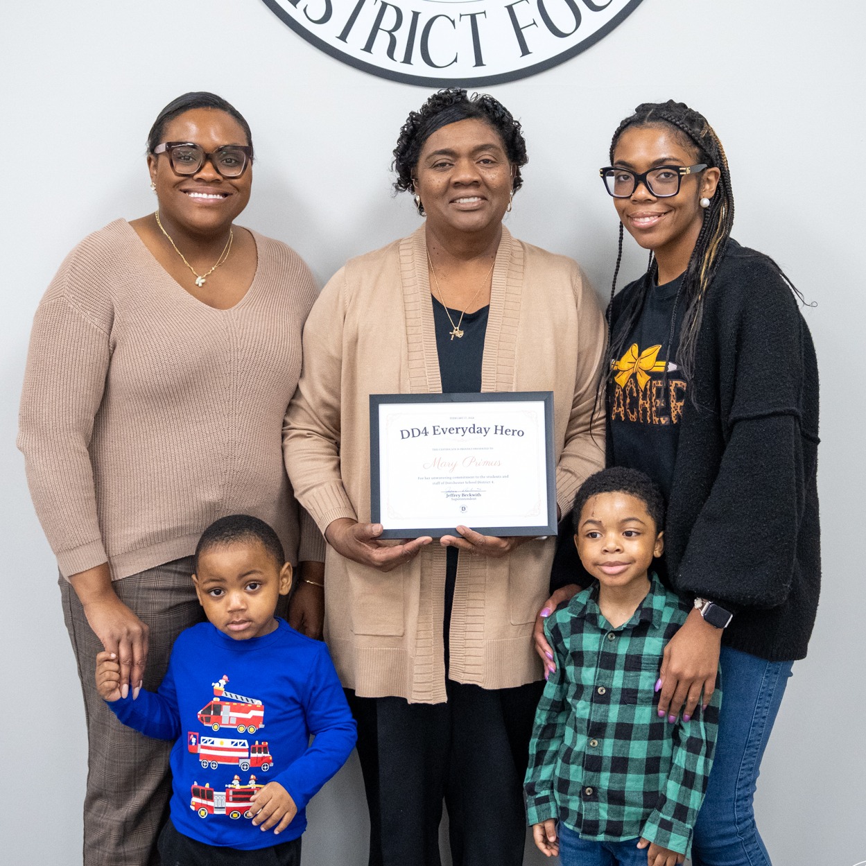 Mary Primus and her family pose with the Everyday hero award in the board room. 