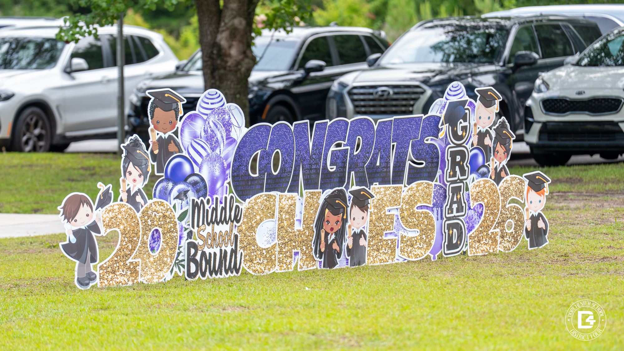 CHES front lawn with a large cutout sign that reads "Congratulations graduates"