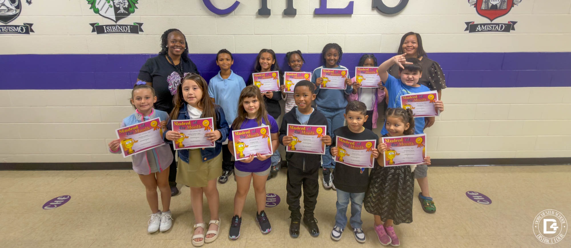 CHES students and staff pose together in the school hallway, holding September Student of the Month certificates.
