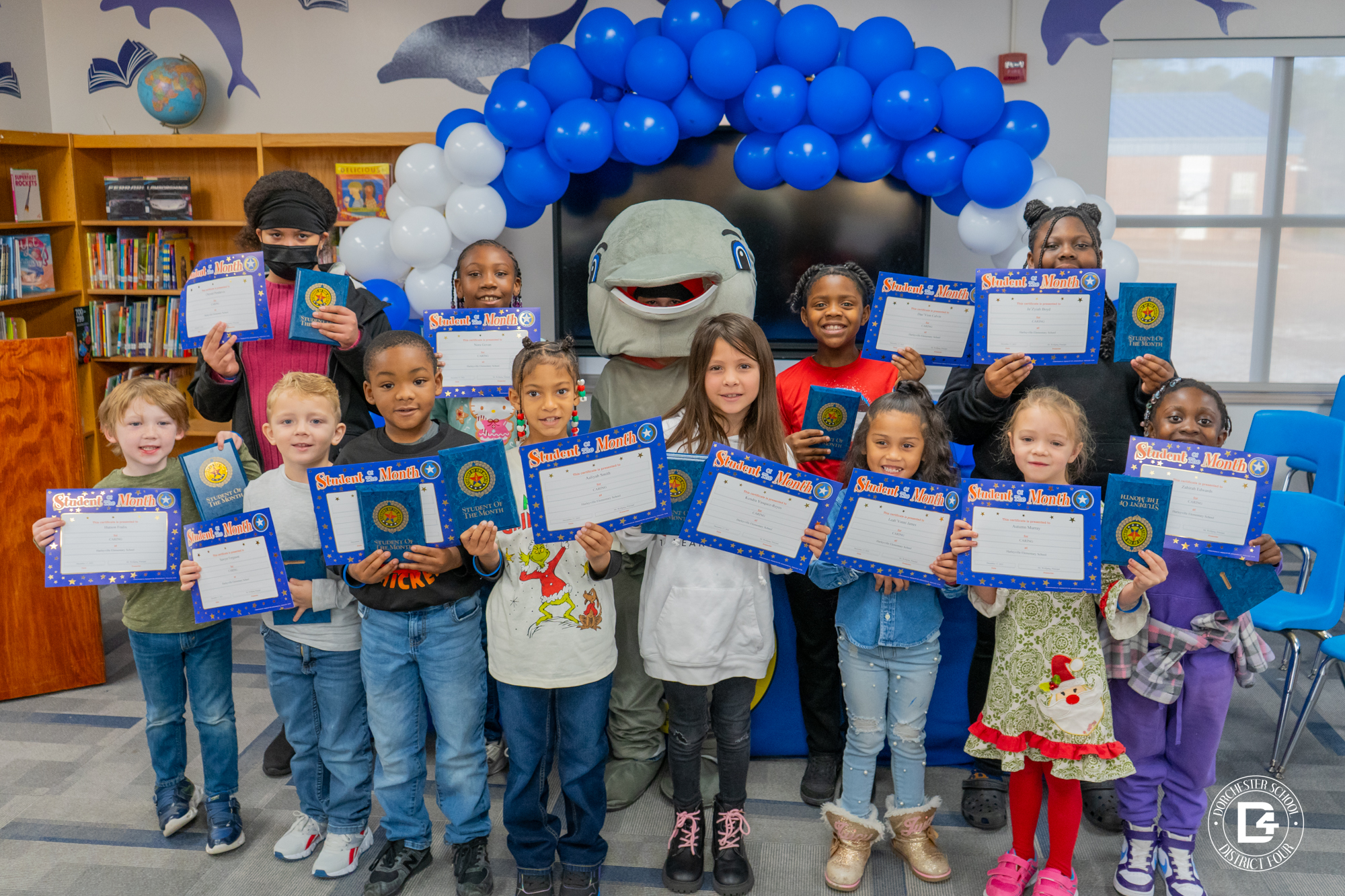 HES December Character students smiling and posing holding their certificates and plaques. 