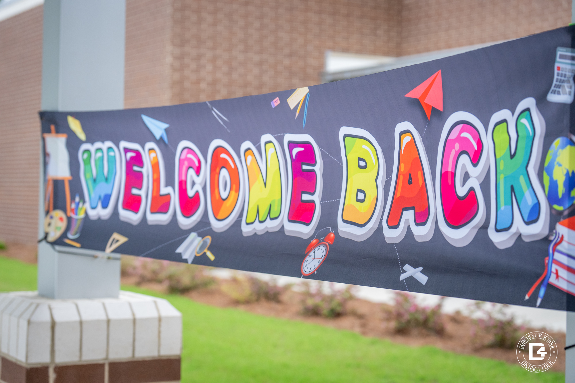 Colorful “Welcome Back” banner displayed outside Woodland Middle School, decorated with school-themed graphics
