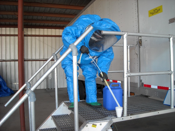 Person in full protective gear atop a set of stairs, cleaning them.