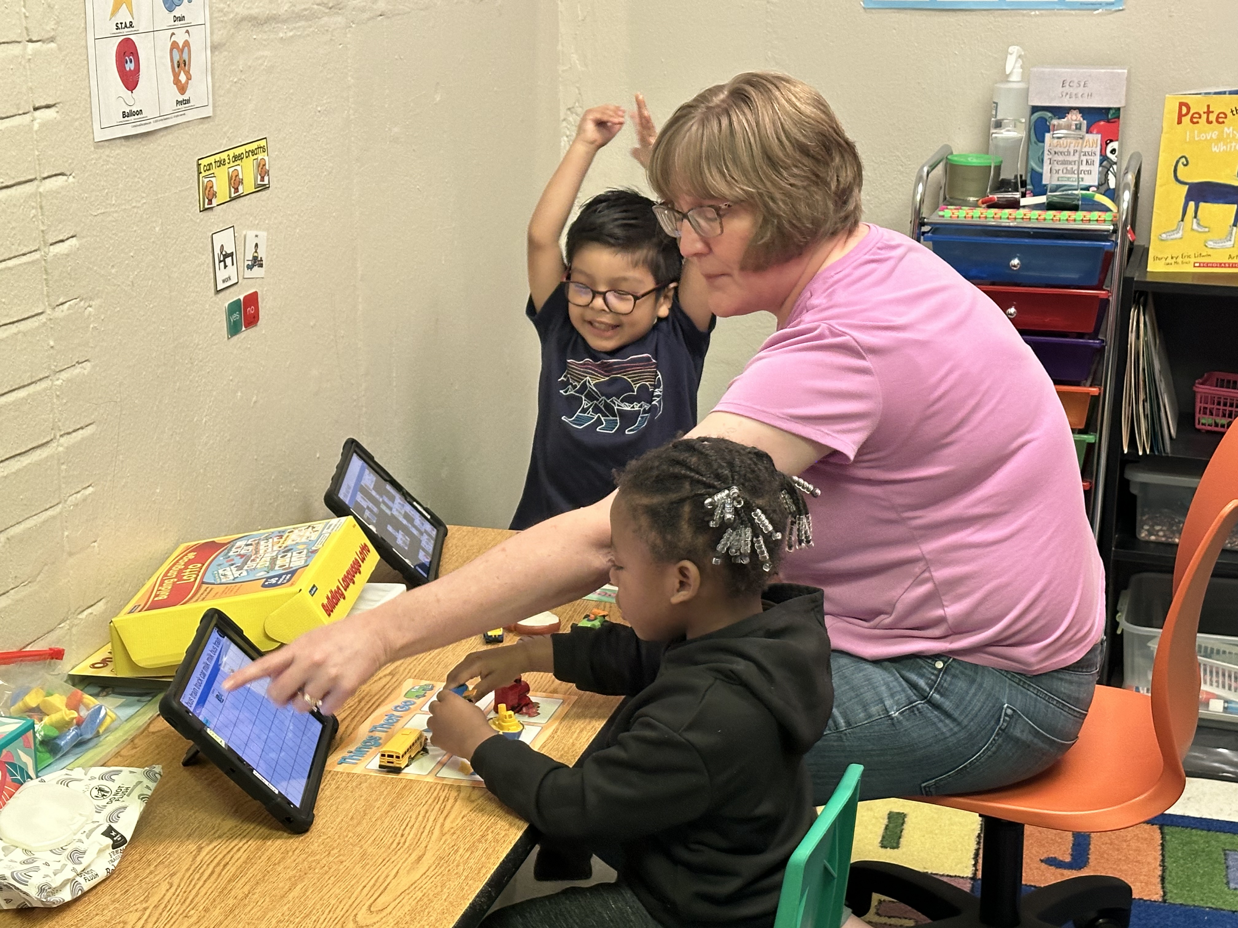 A teacher works with two students