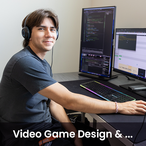 Student smiling while working on computer coding