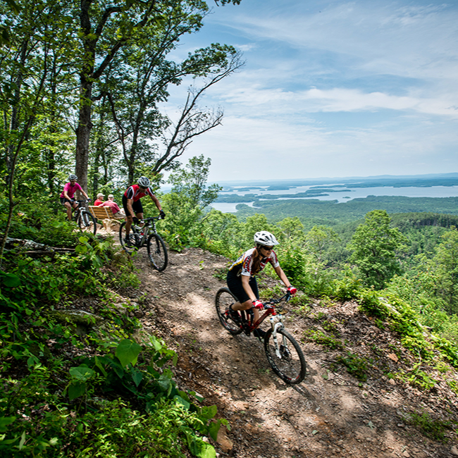 cyclists going down a mountain trail with a view of the arkansas river