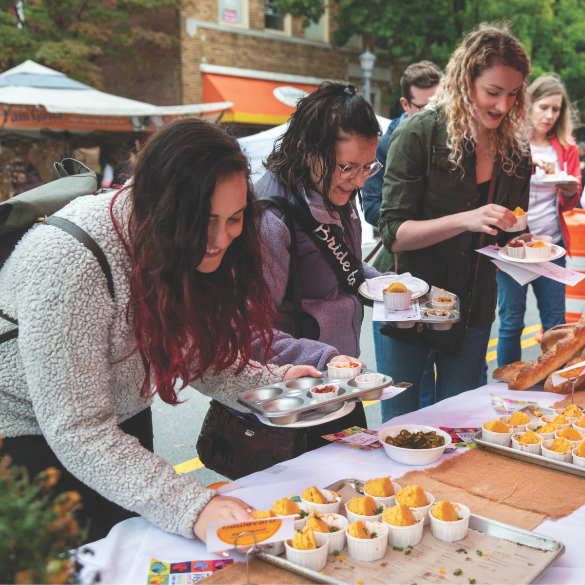 three women visiting a food fest and getting food samples