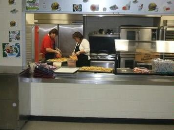  A couple of people in a kitchen preparing food