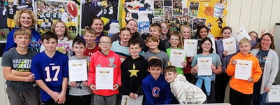 A group of children holding up their awards