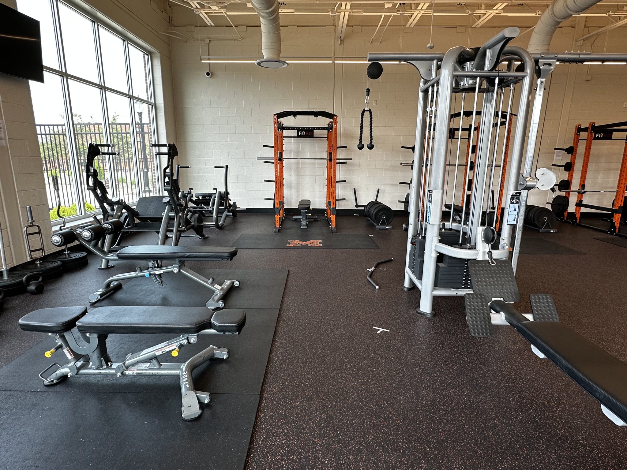 A spacious gym filled with various weights and exercise machines, ready for a workout session.