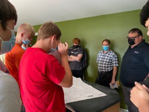 A group of masked individuals gathered around a table