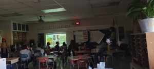 A busy classroom filled with students sitting at desks