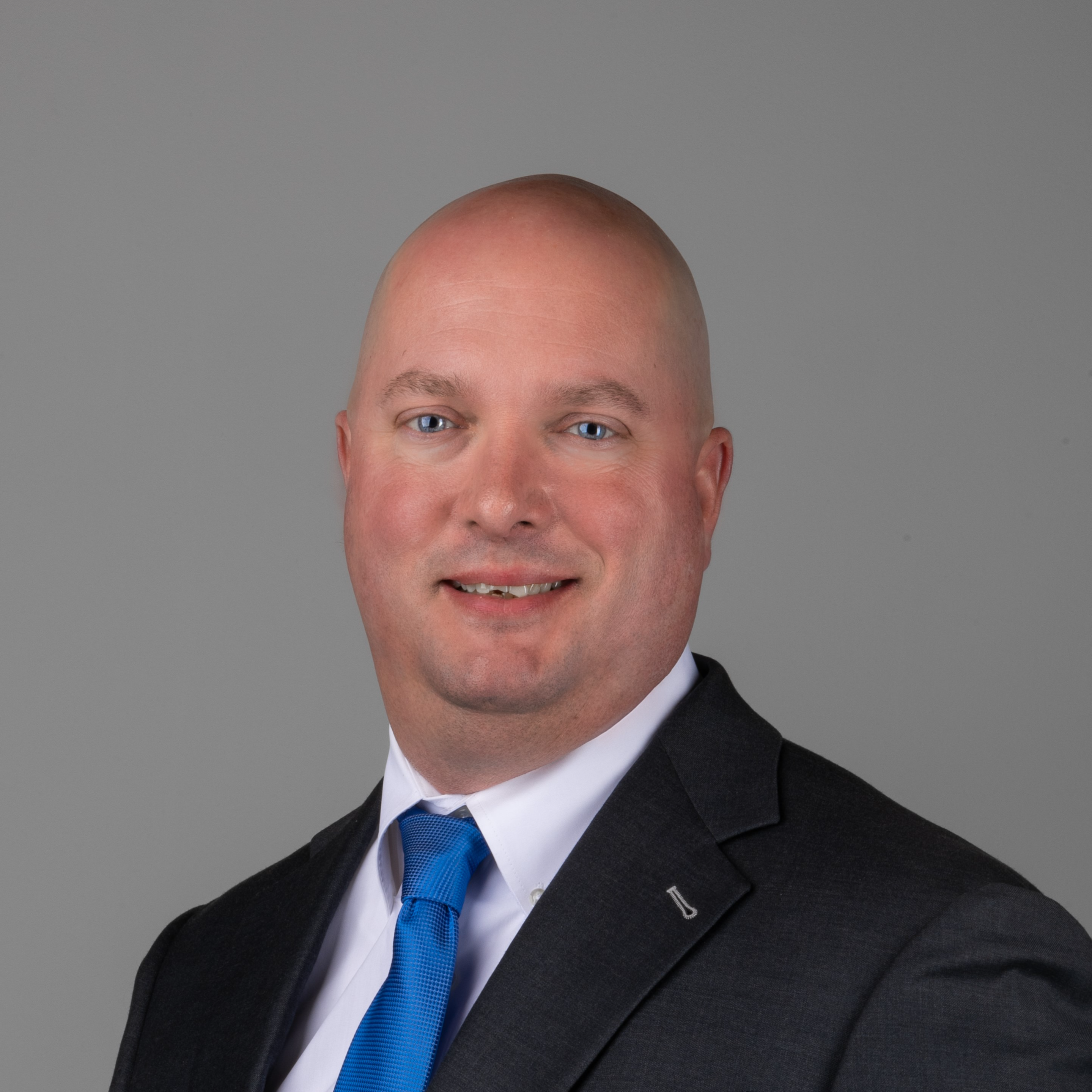 professional headshot of man in black suit