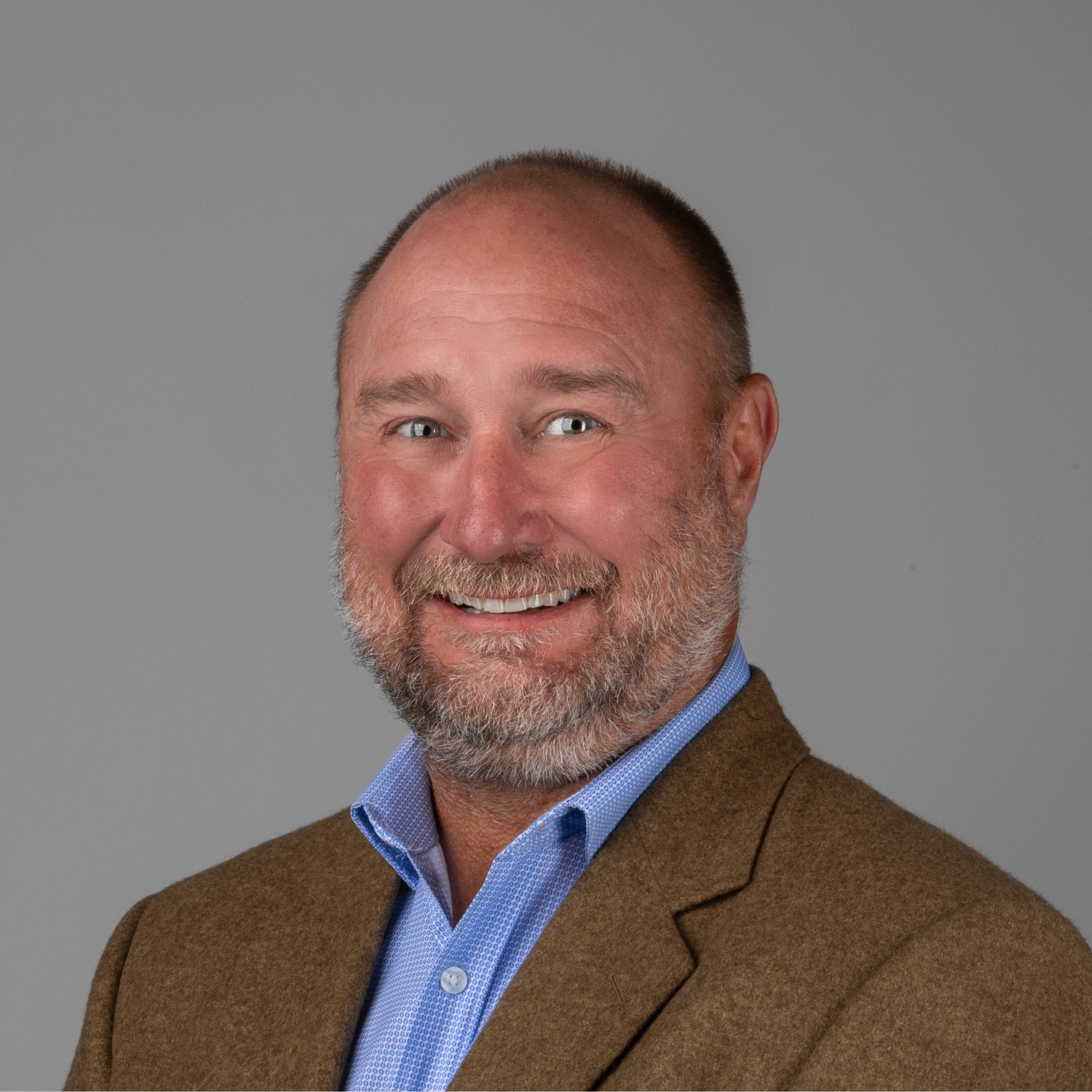 professional headshot of man in brown suit