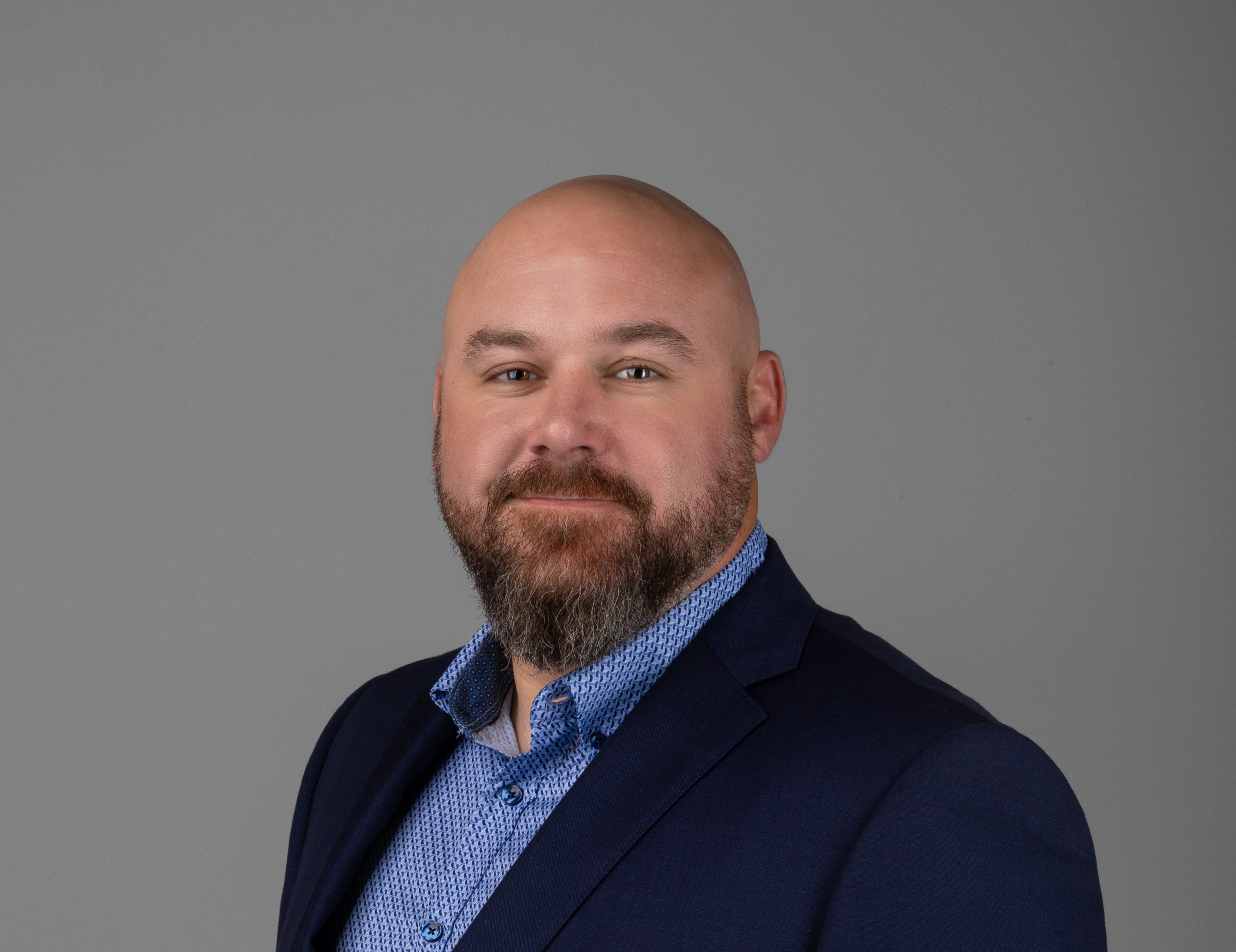 professional headshot of man in black suit