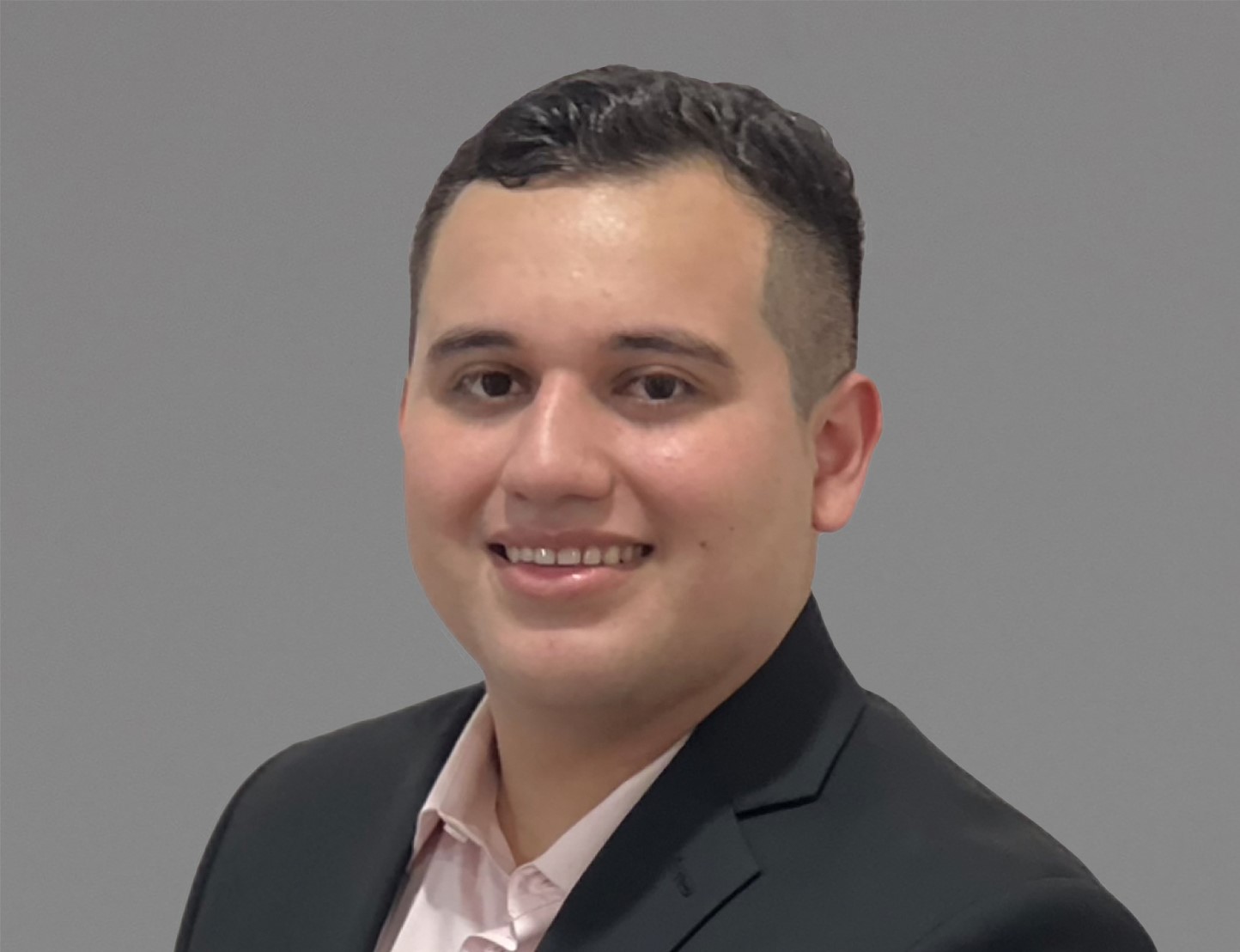 professional headshot of man in black suit