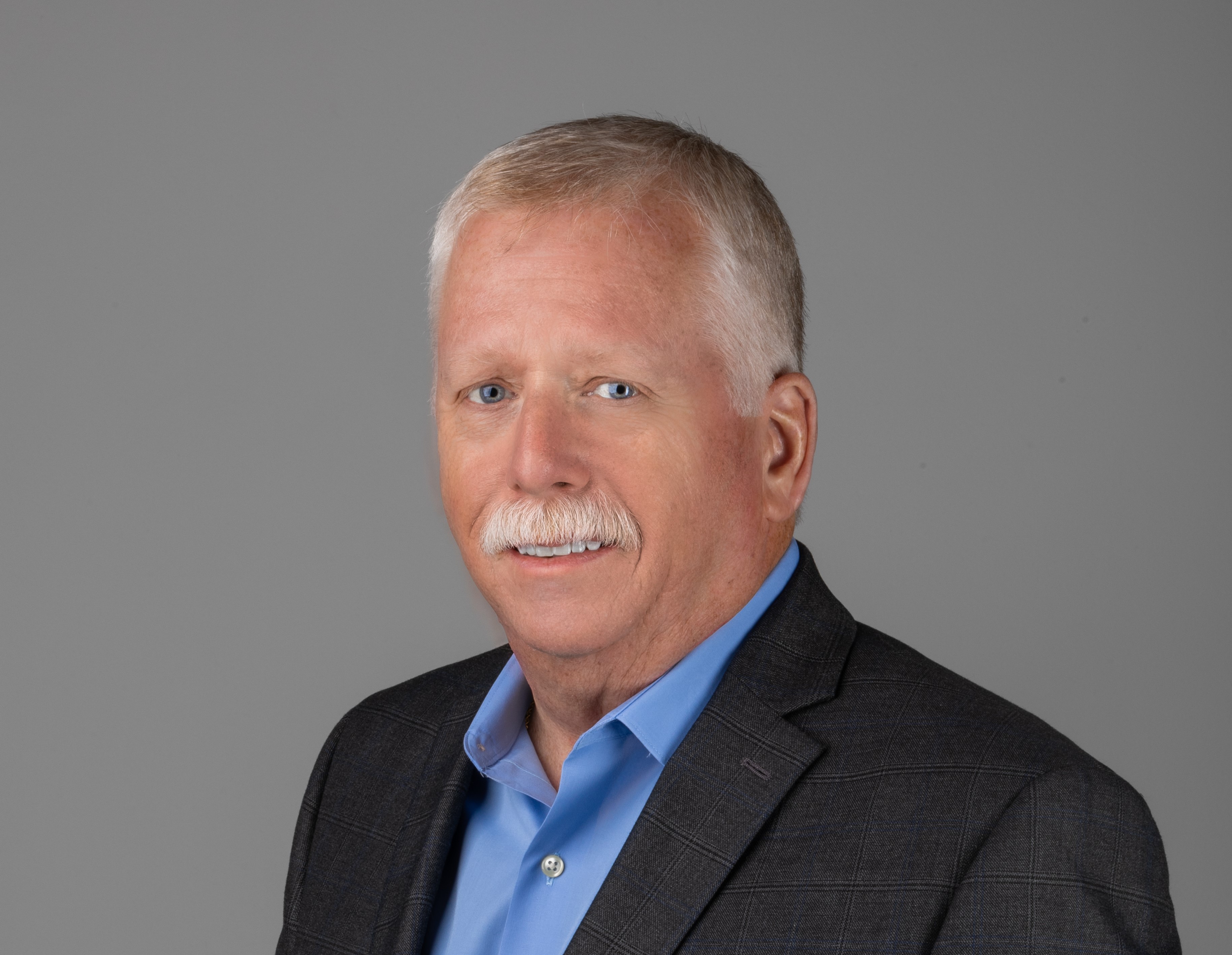 professional headshot of man in blue suit