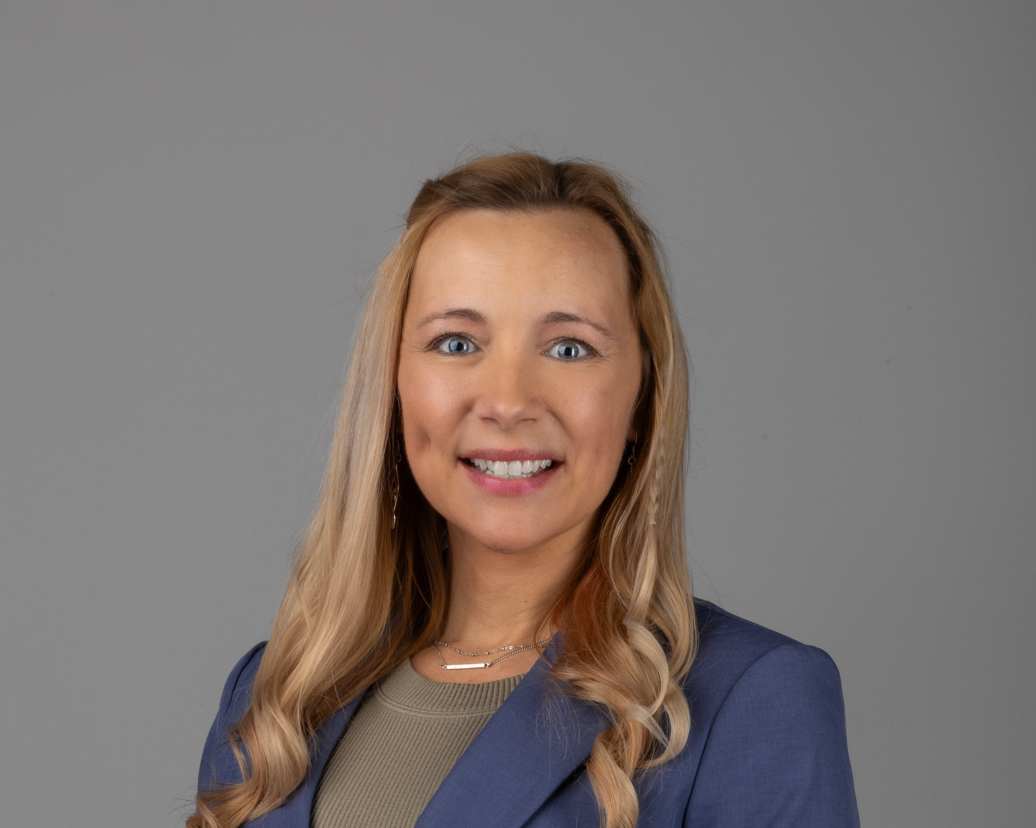 professional headshot of woman in blue suit