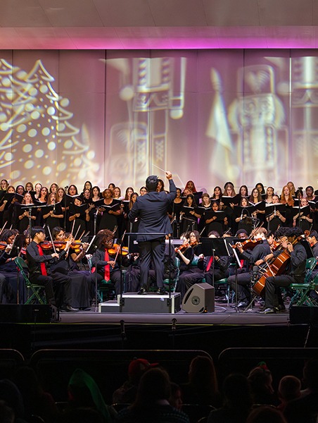 Chior and orchestra performing on stage.