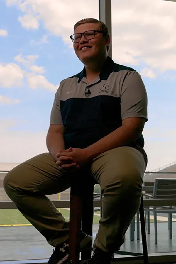 Zach Berger sitting in a chair overlooking a football stadium.