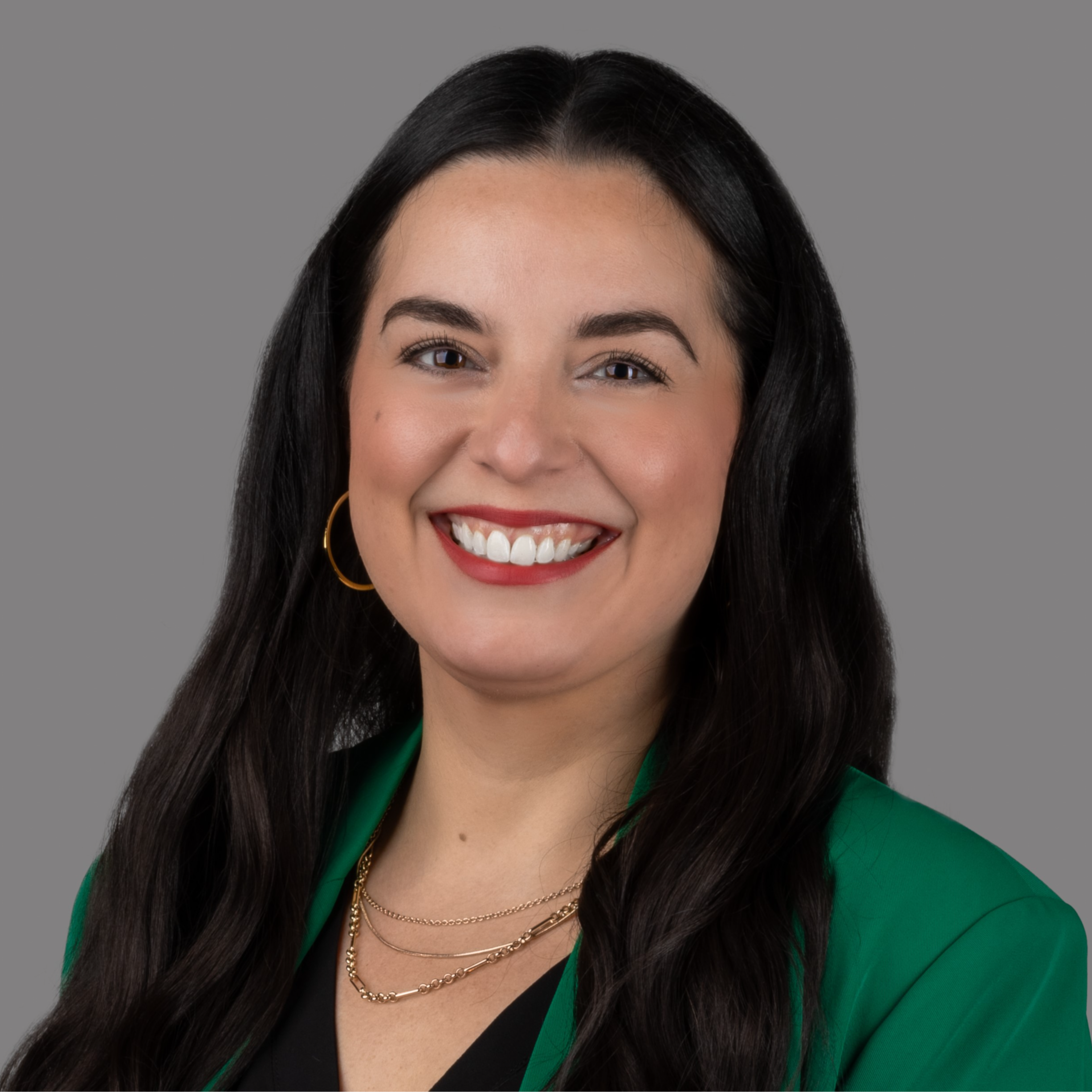 professional headshot of woman in green suit
