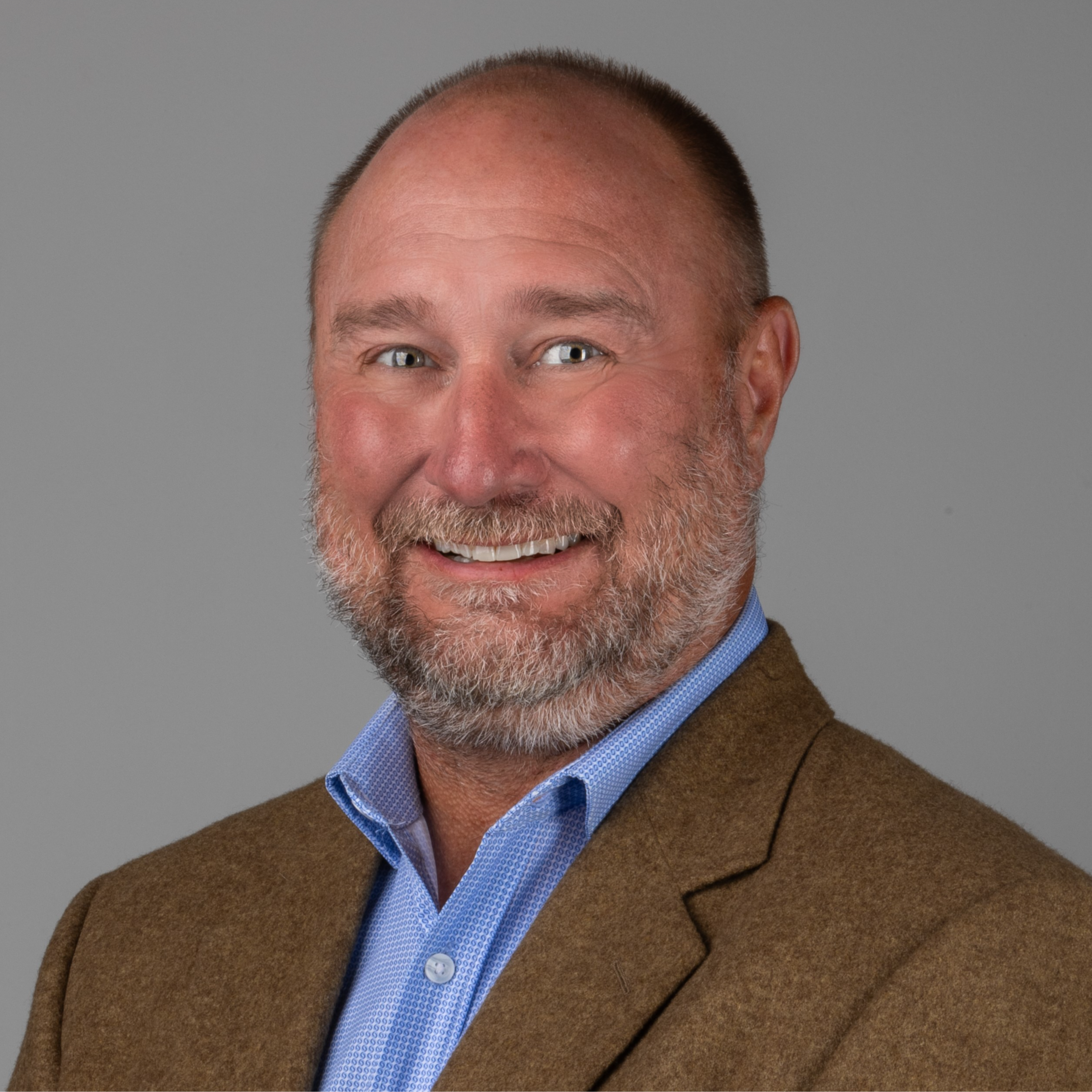 professional headshot of man in brown suit