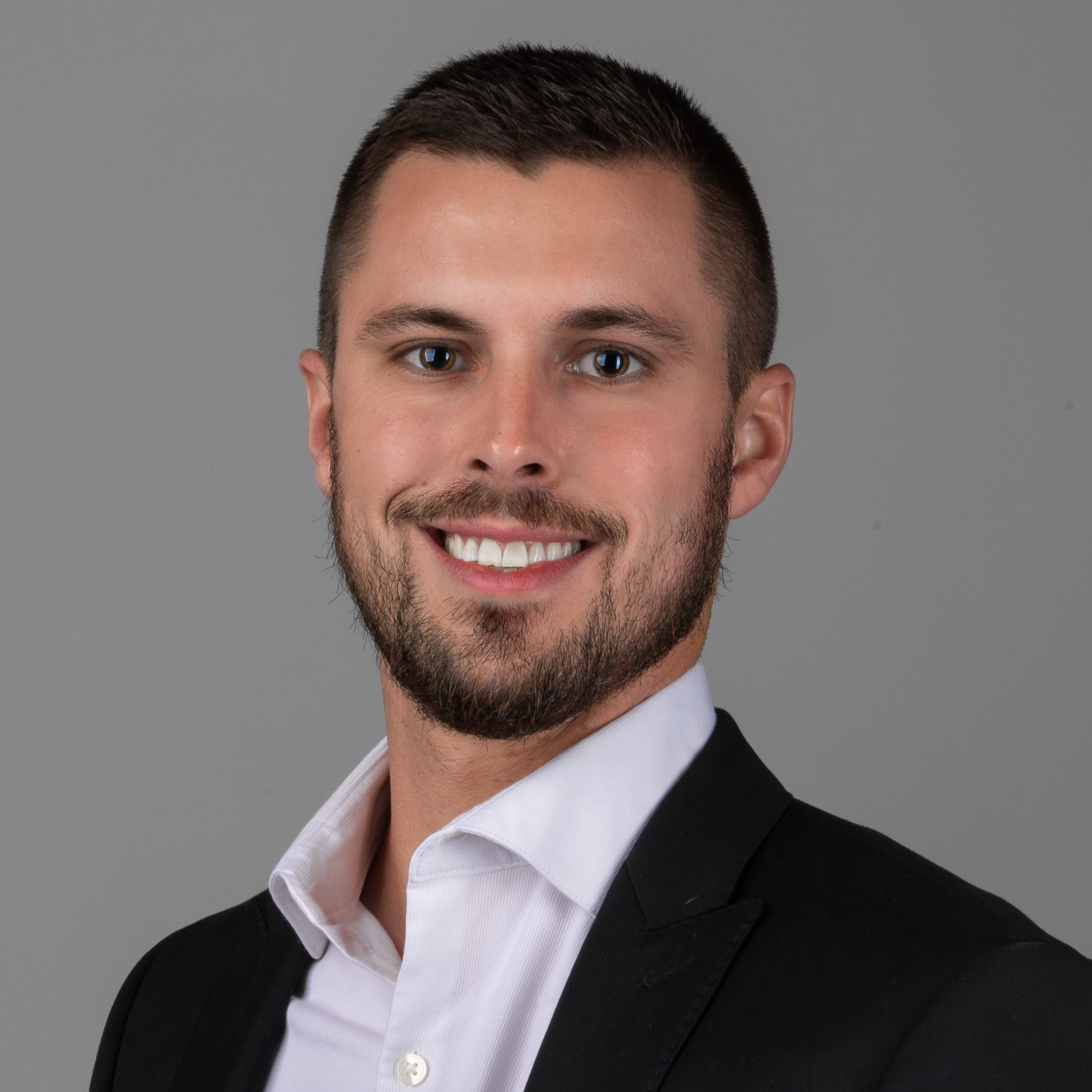 professional headshot of man in black suit