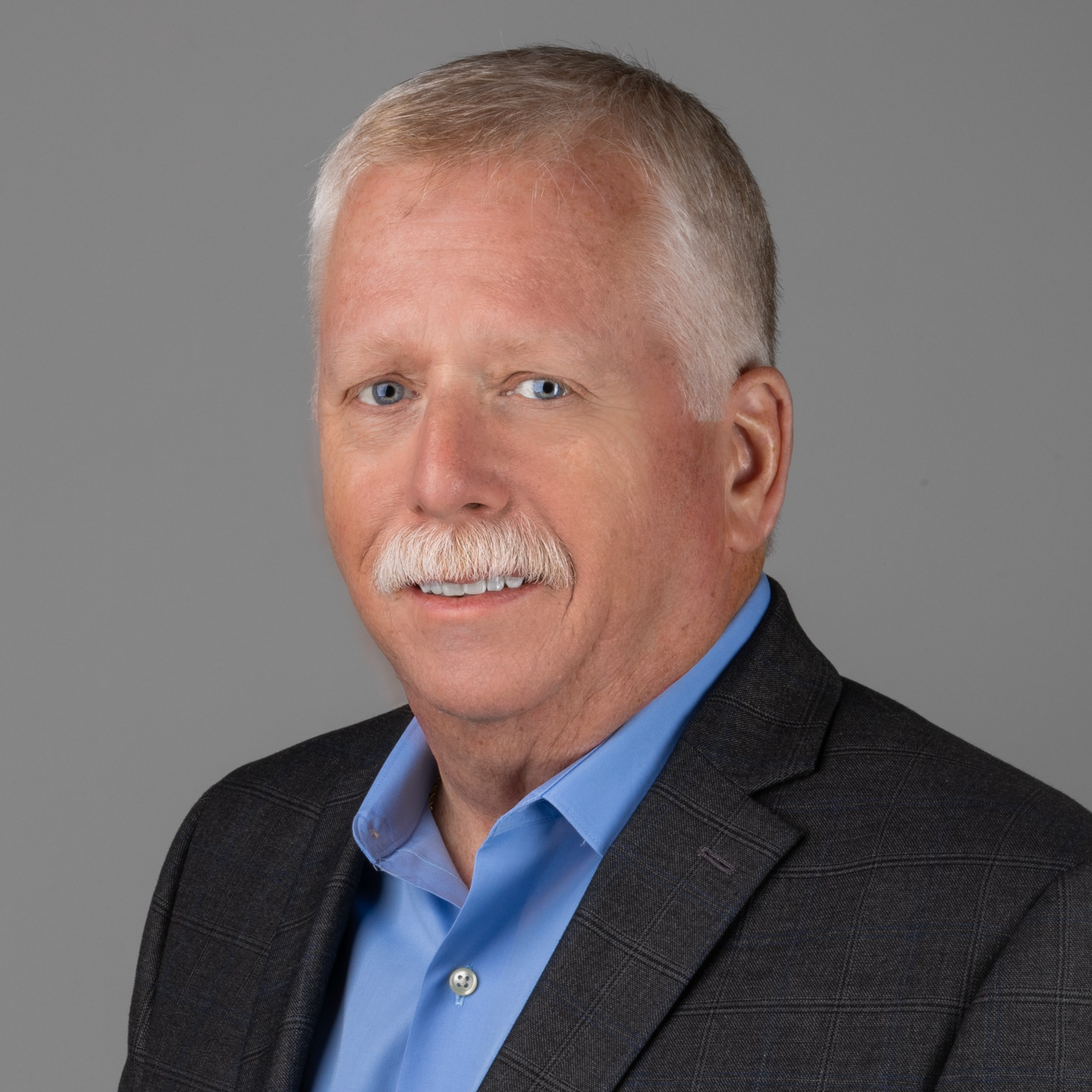 professional headshot of man in blue suit