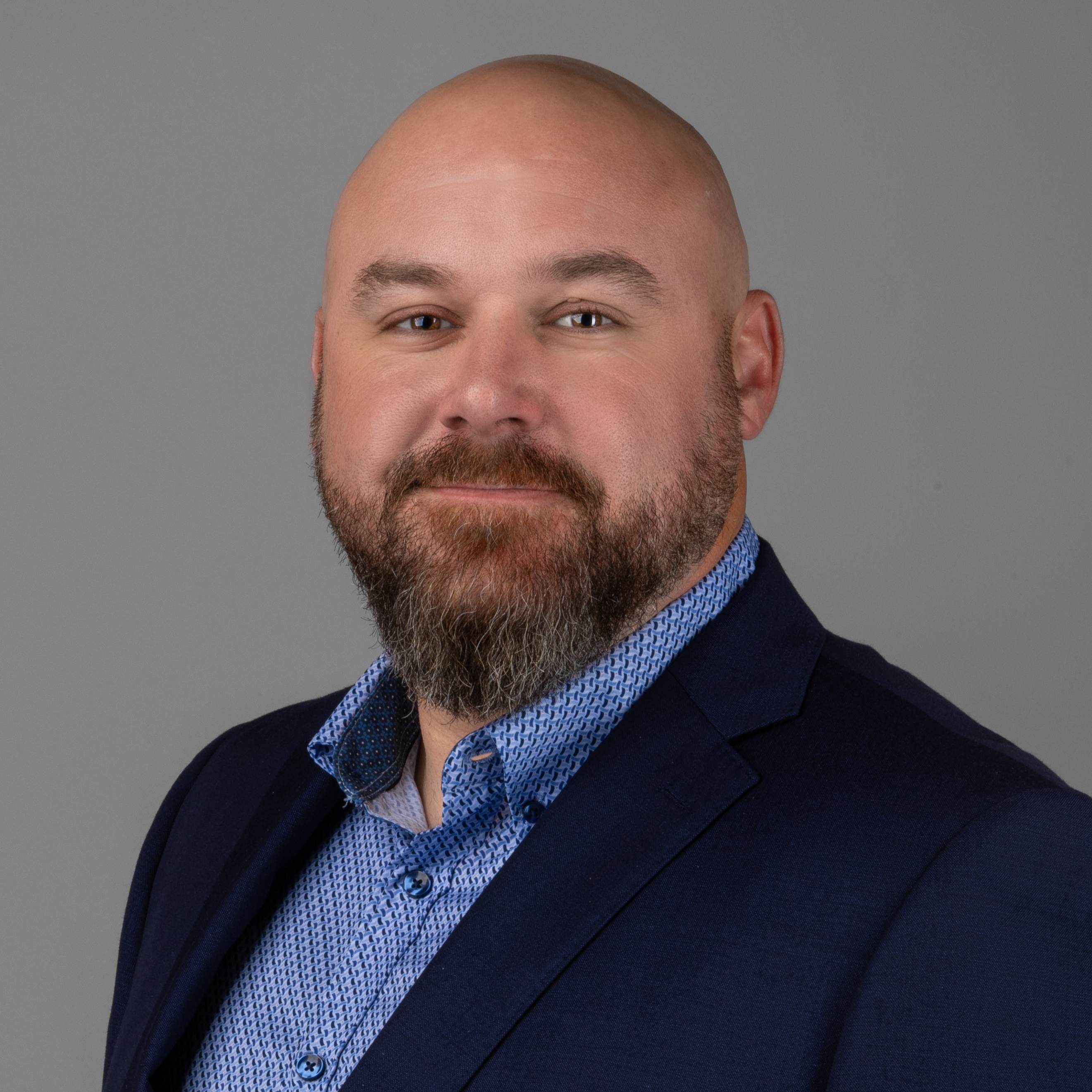 professional headshot of man in black suit