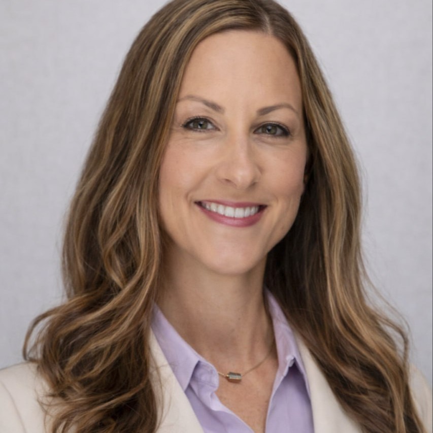 Heather baker, Elementary MAth Disctict Instructional Coach. She is wearing a black blazer with a green and white stiped collared shirt.