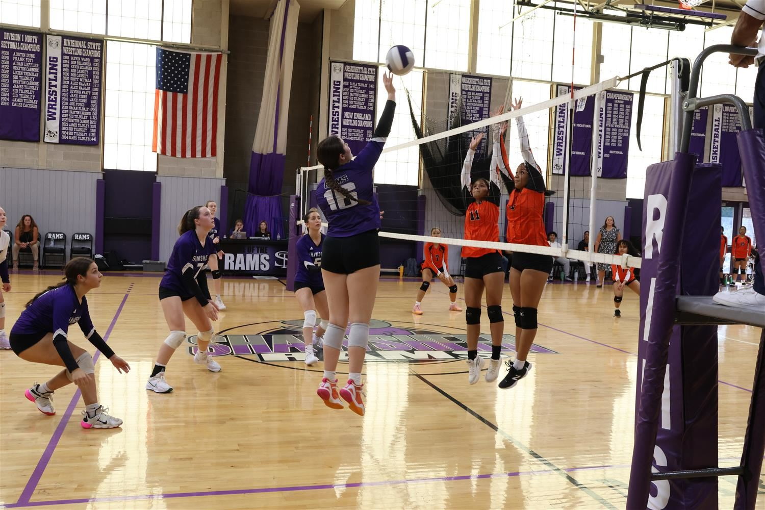 Volleyball team competes energetically on the court, showcasing teamwork and athleticism during a match.