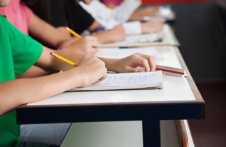 A hand of a student holding a pencil and writing