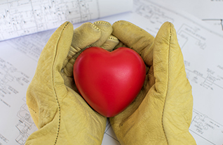 Hands cradle a red heart, symbolizing love and care.