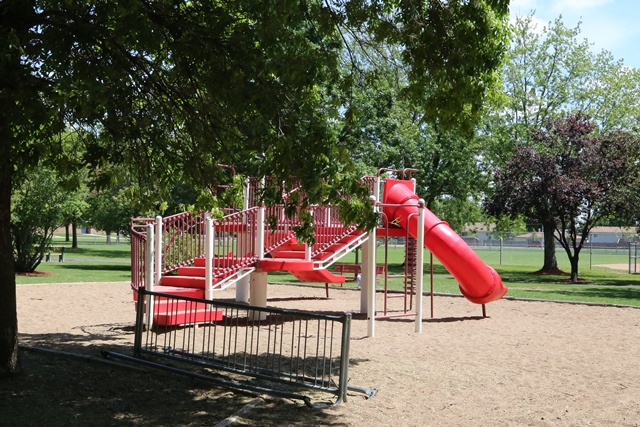 A playground with a red slide and a red slide