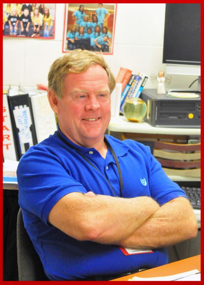 A man sitting at a desk with his arms crossed