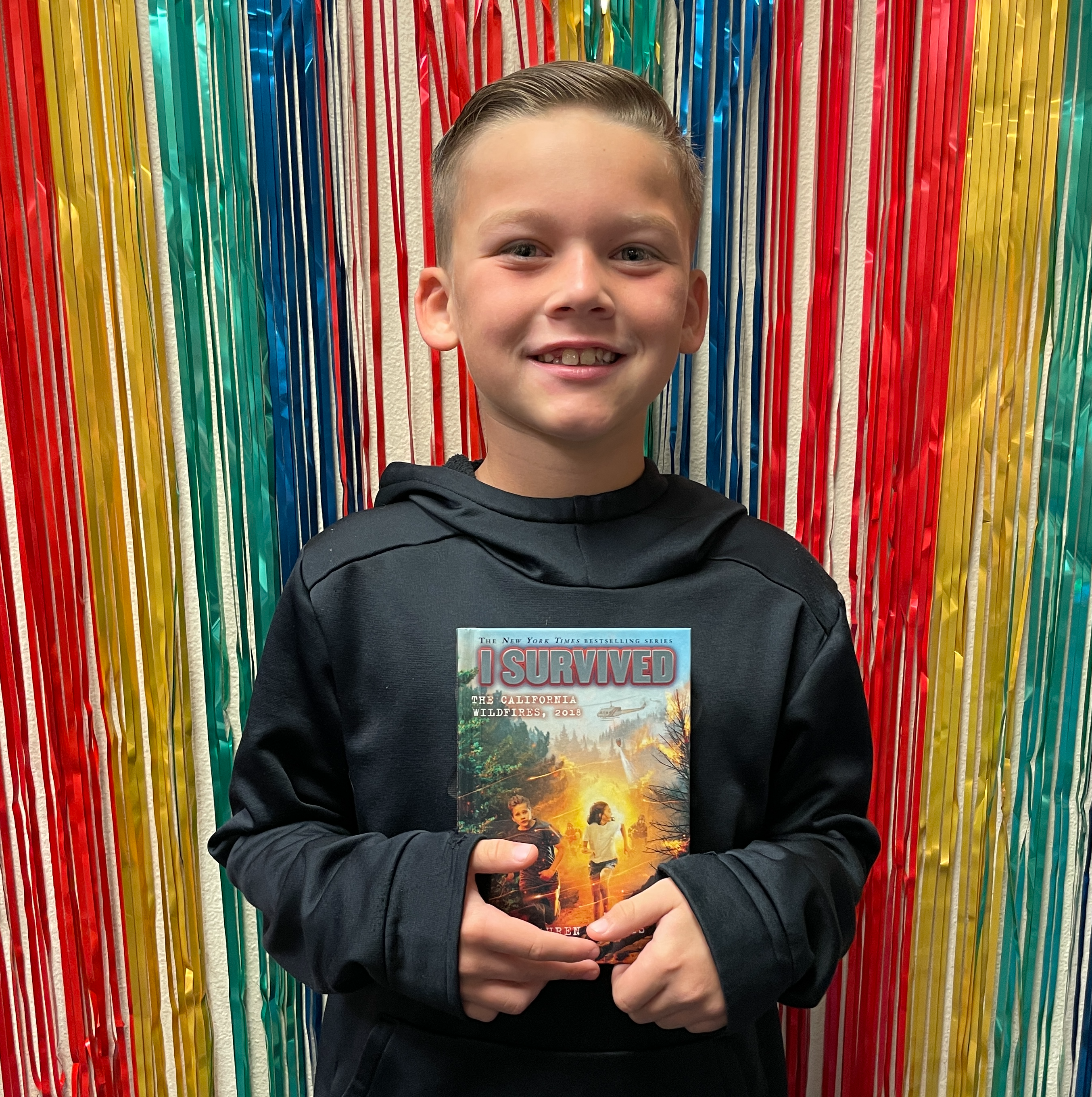 Boy in front of birthday backdrop