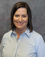 A woman wearing a blue shirt and white skirt.