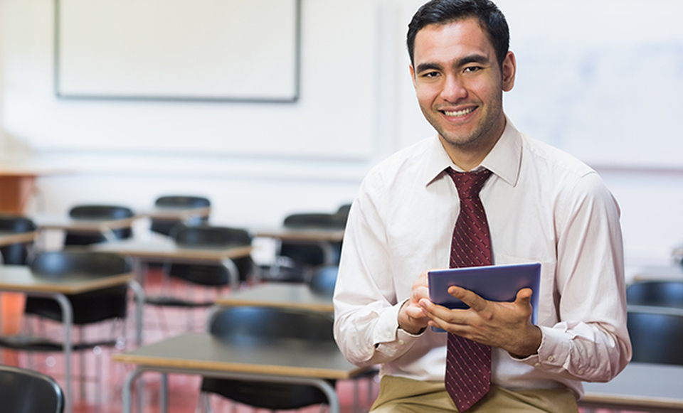 A man in a shirt and tie holding a tablet.