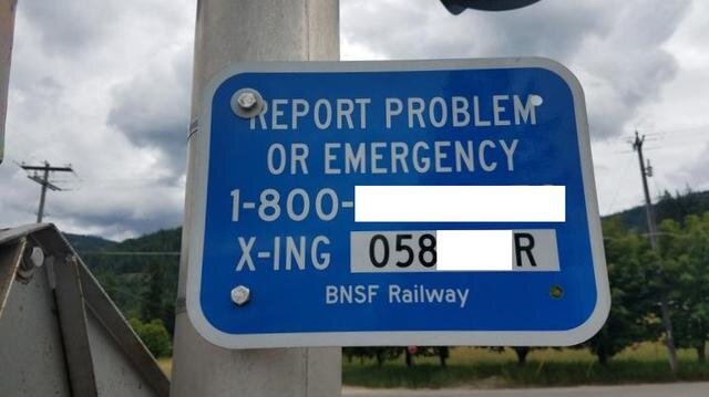 A blue sign that says "Report Problem or Emergency,"